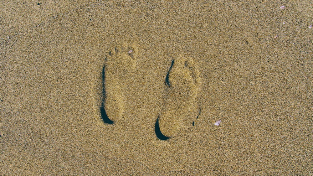 person's foot print on brown sands