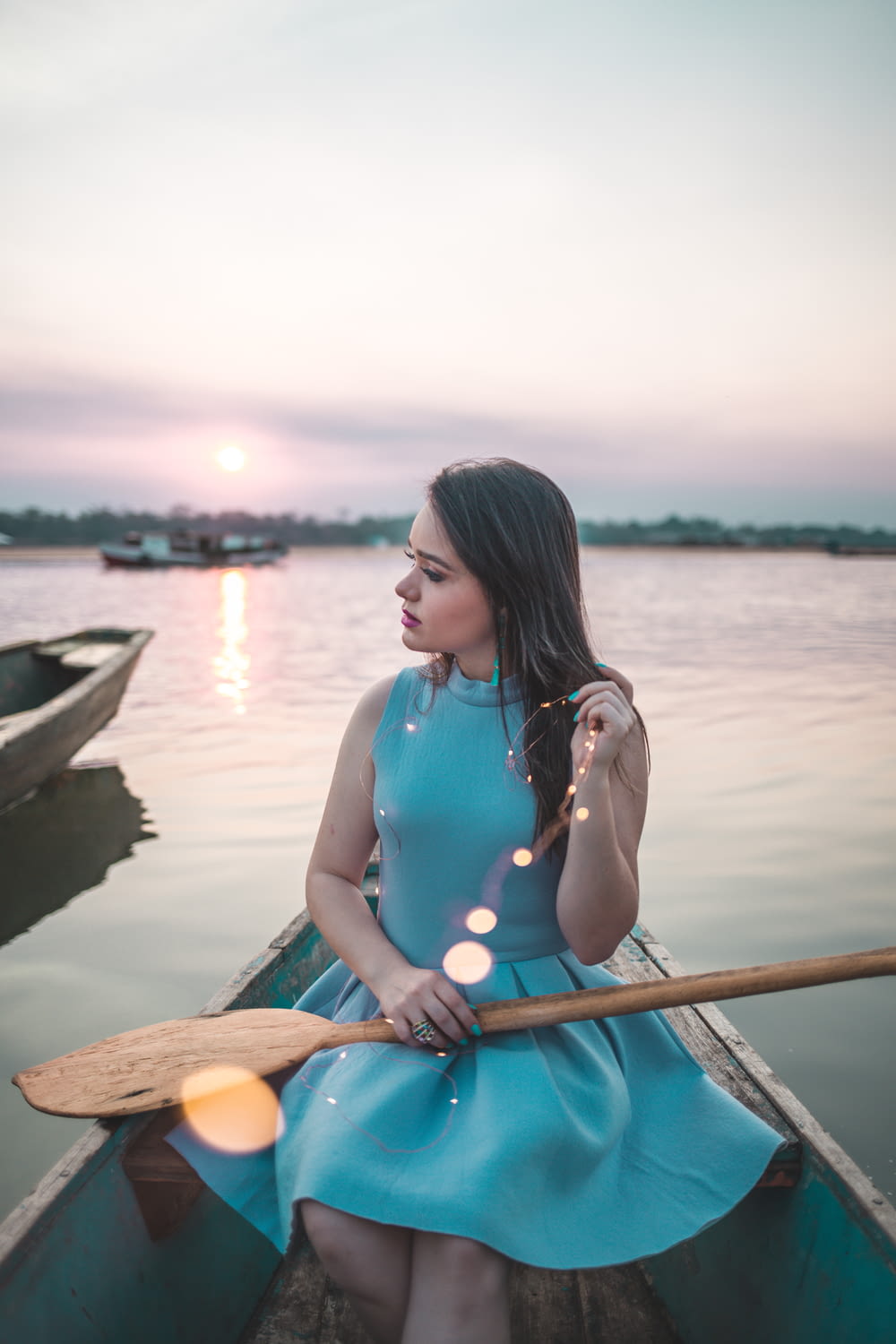 woman sitting on boat holding paddle