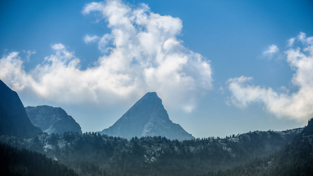 landscape photography of mountains under white clouds