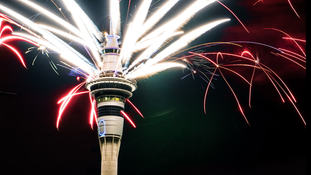 fireworks are lit up in the sky above a tower