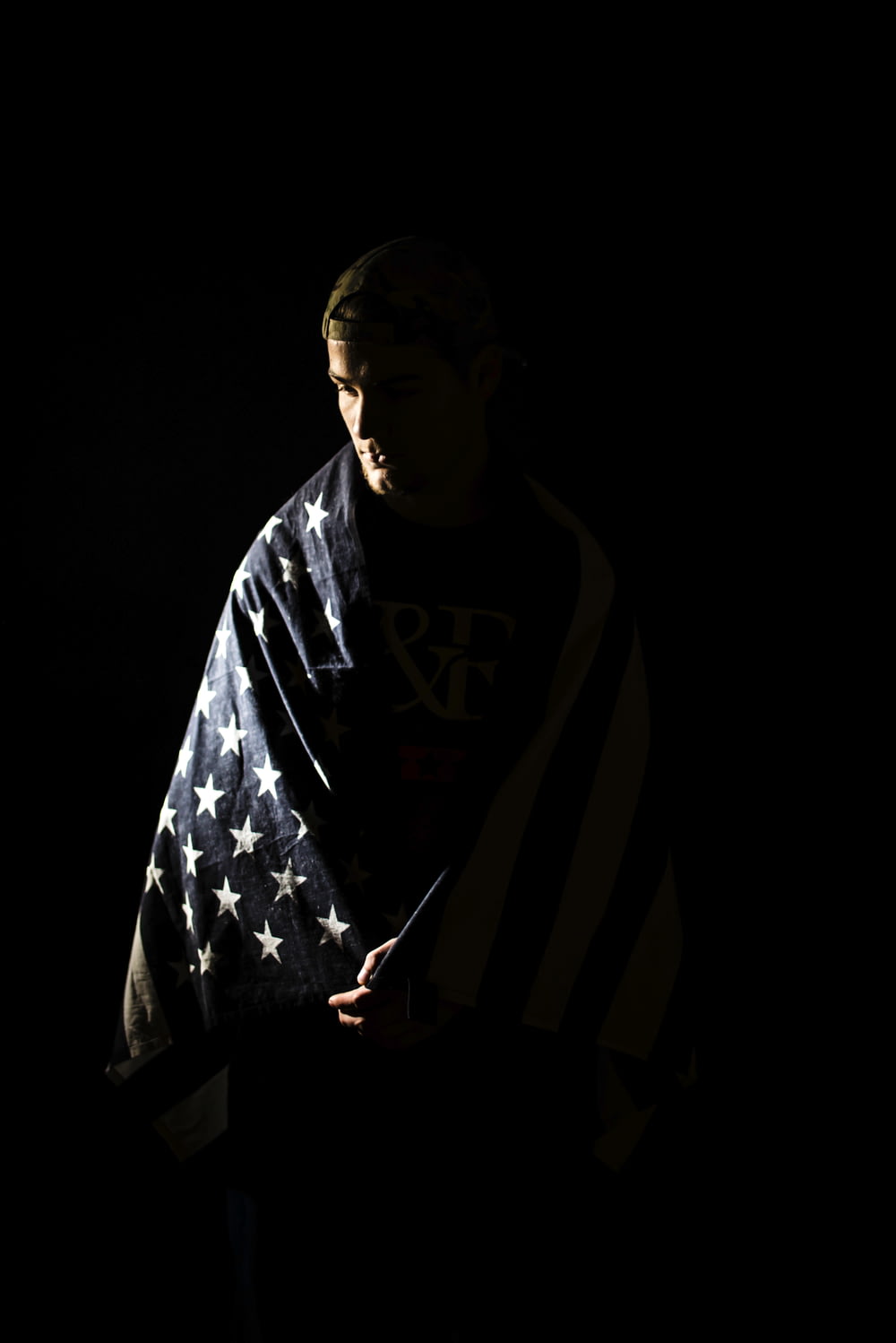 a man wrapped in an american flag in the dark