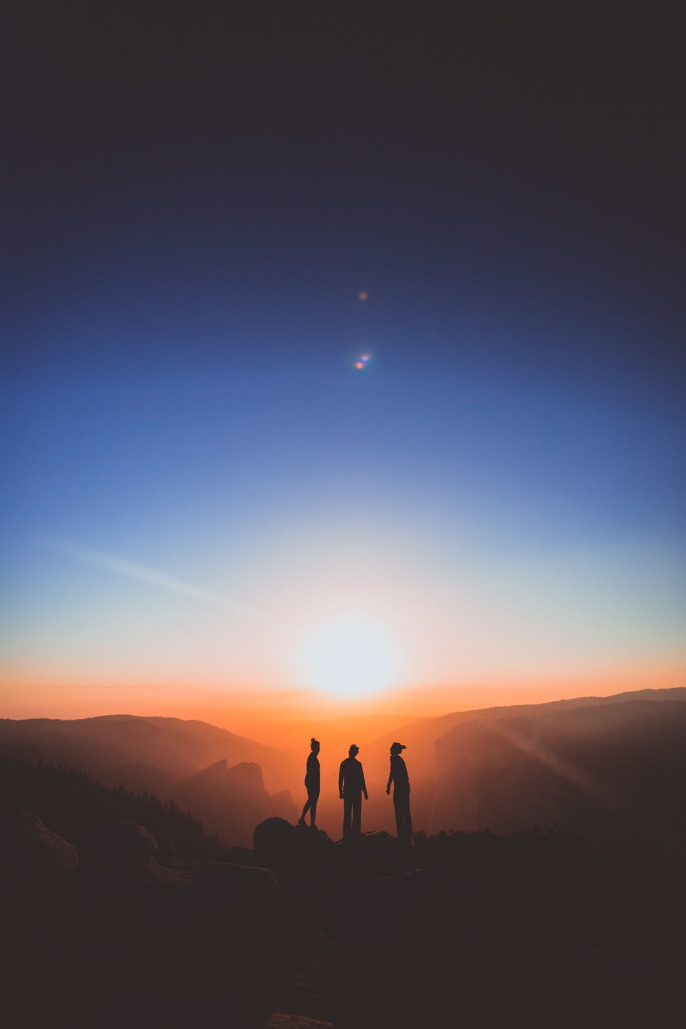 silhouette de trois personnes debout sur la montagne
