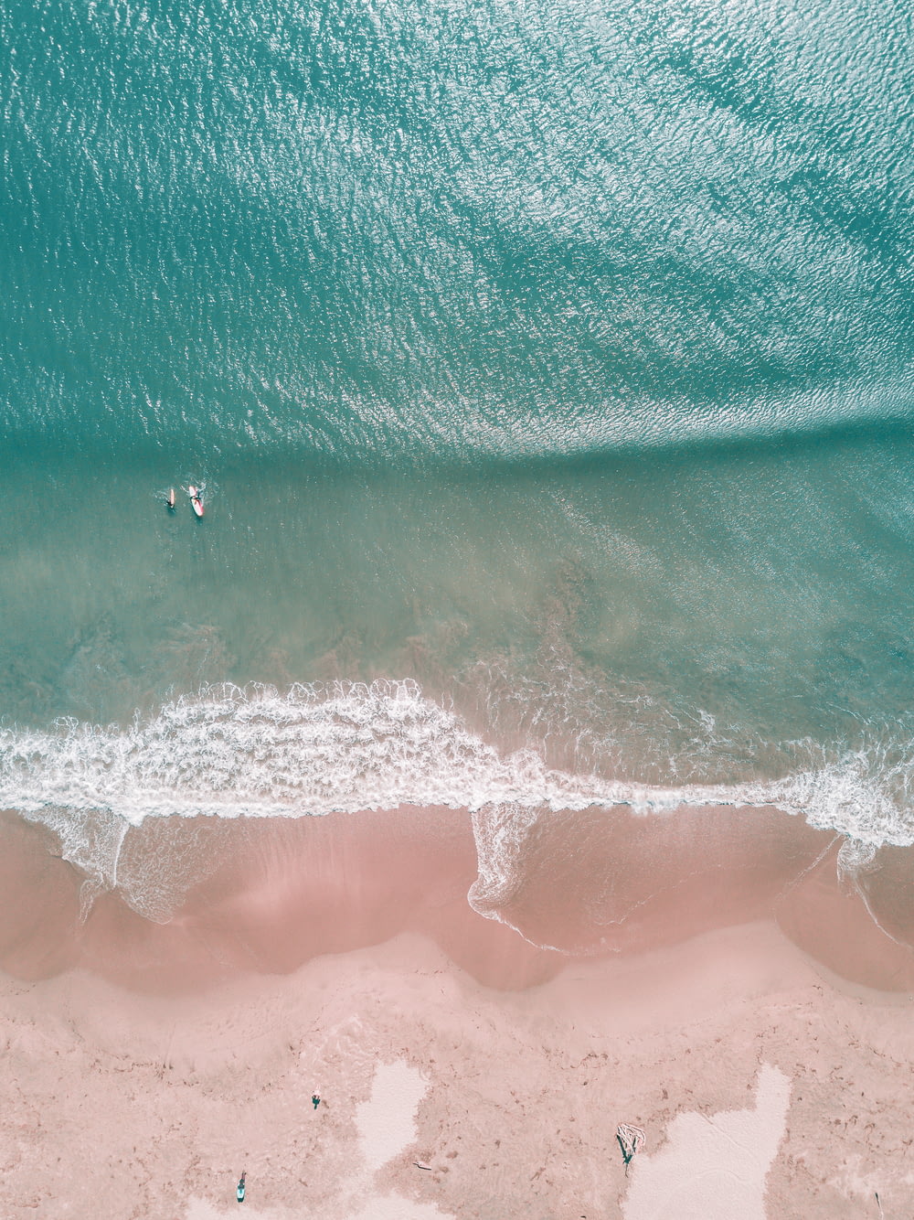 aerial photography of people surfing on seashore during daytime