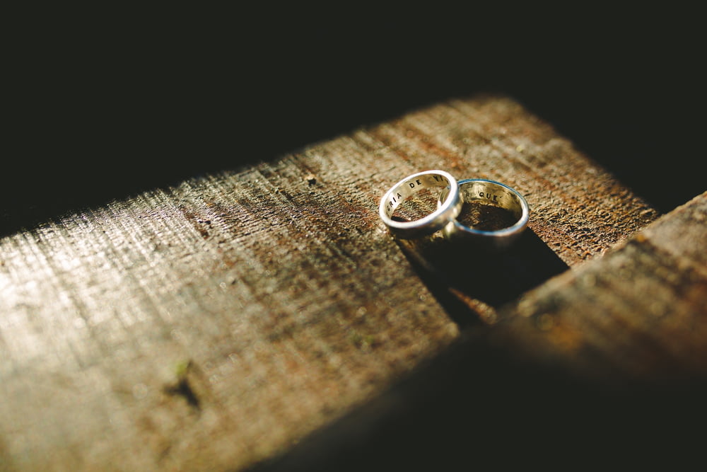 due anelli di fidanzamento color argento sulla superficie superiore marrone