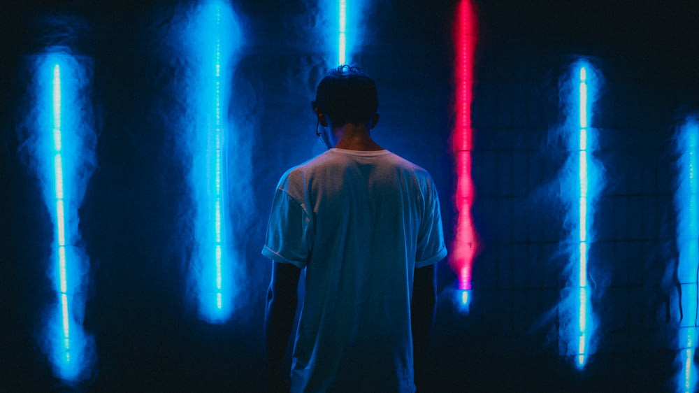 man standing near blue LED strips