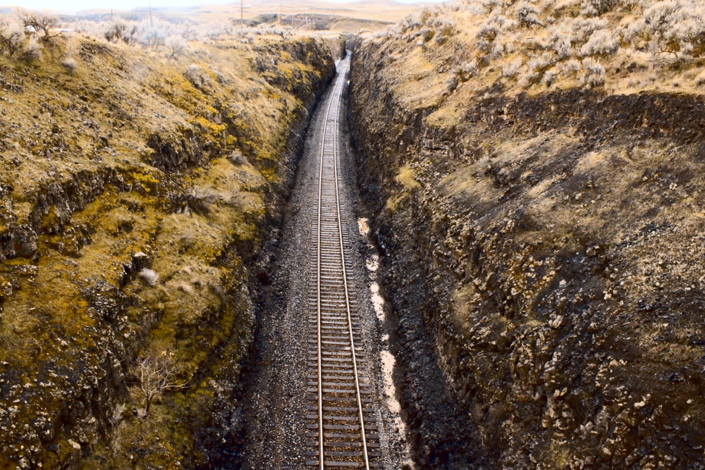 railway between brown rocky hills