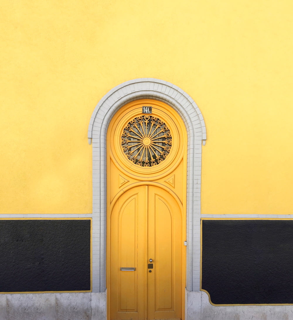 yellow wooden door between yellow wall