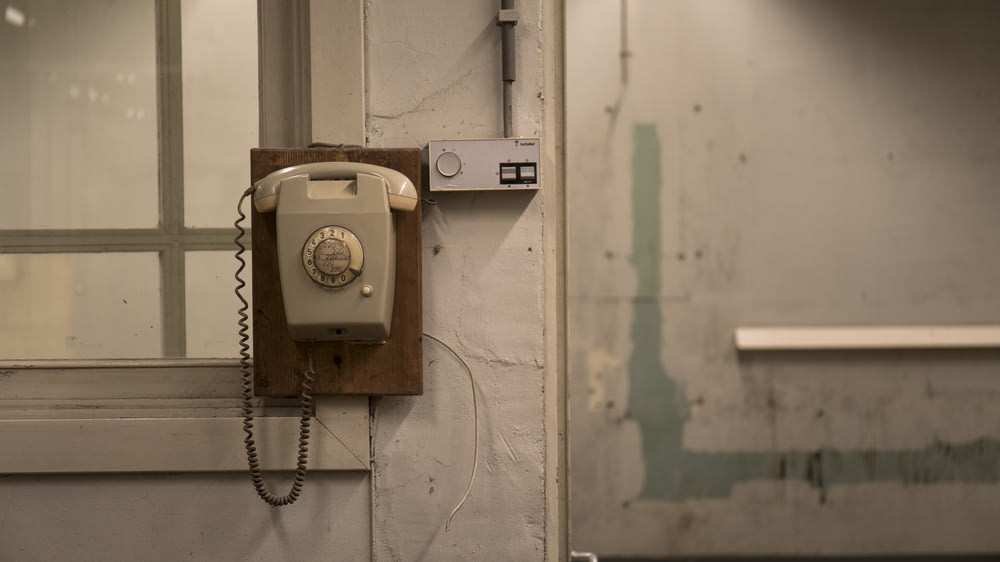 Un teléfono viejo está colgado en una pared