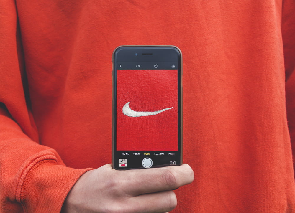 Person mit iPhone, die ein Foto auf dem Nike-Etikett macht