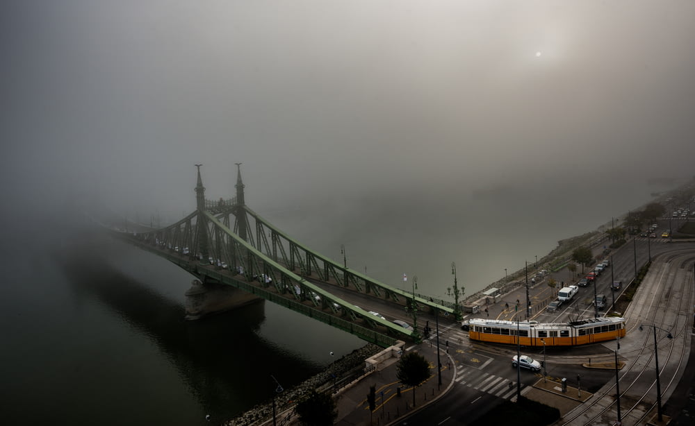 白い雲に覆われた灰色のコンクリート橋へ向かう列車