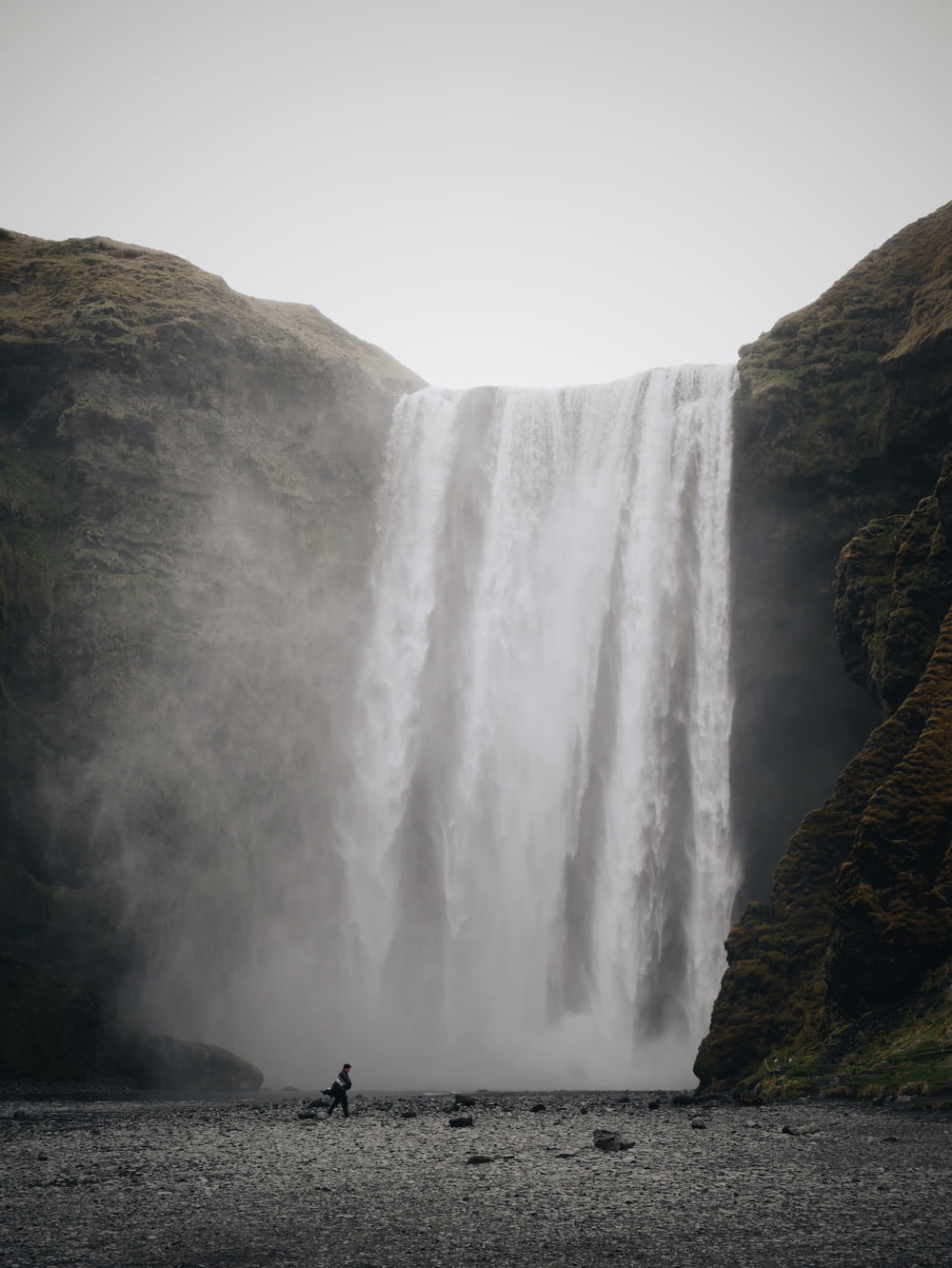 person standing near waterfalls