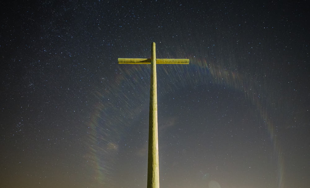 Estatua de la cruz gris durante la noche