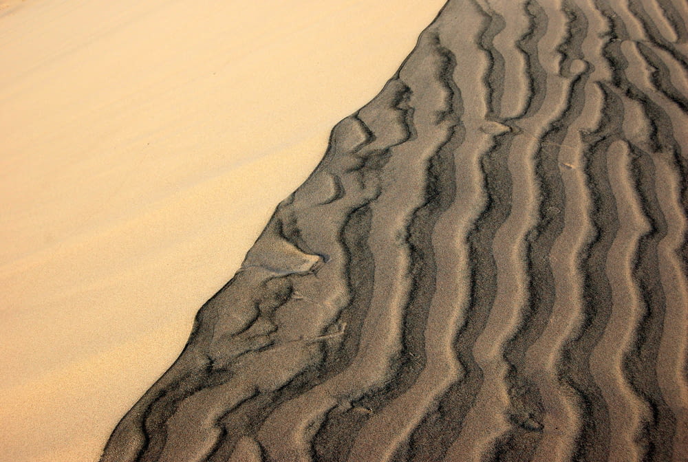 a sand dune with wavy lines in the sand
