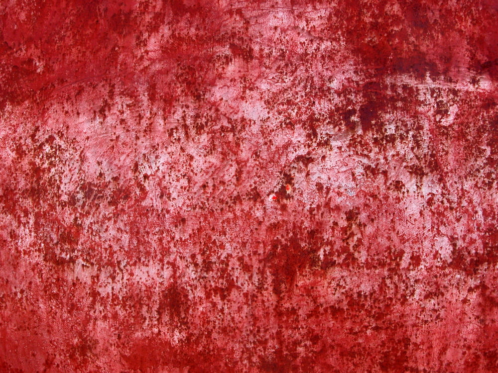 a red wall with a lot of rust on it