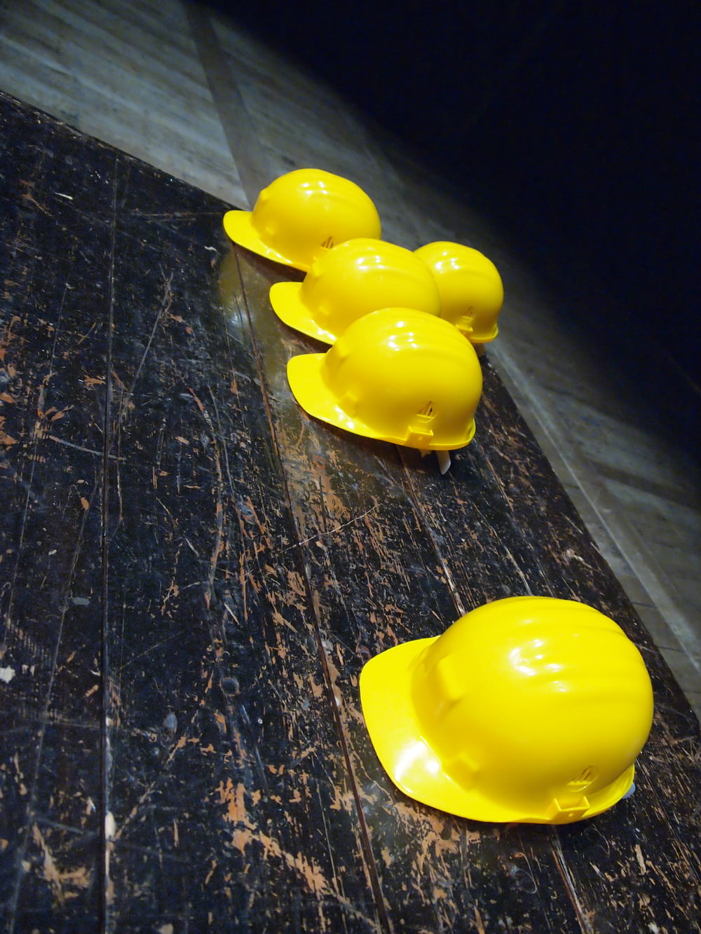 Cinco cascos amarillos sobre superficie gris