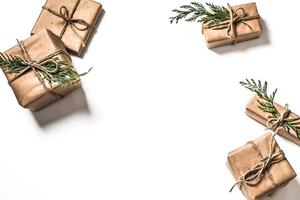 Quattro scatole regalo marroni su superficie bianca