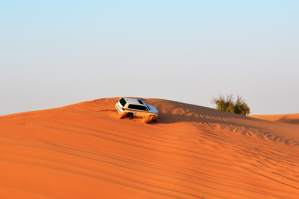 white SUV on desert during daytime photo