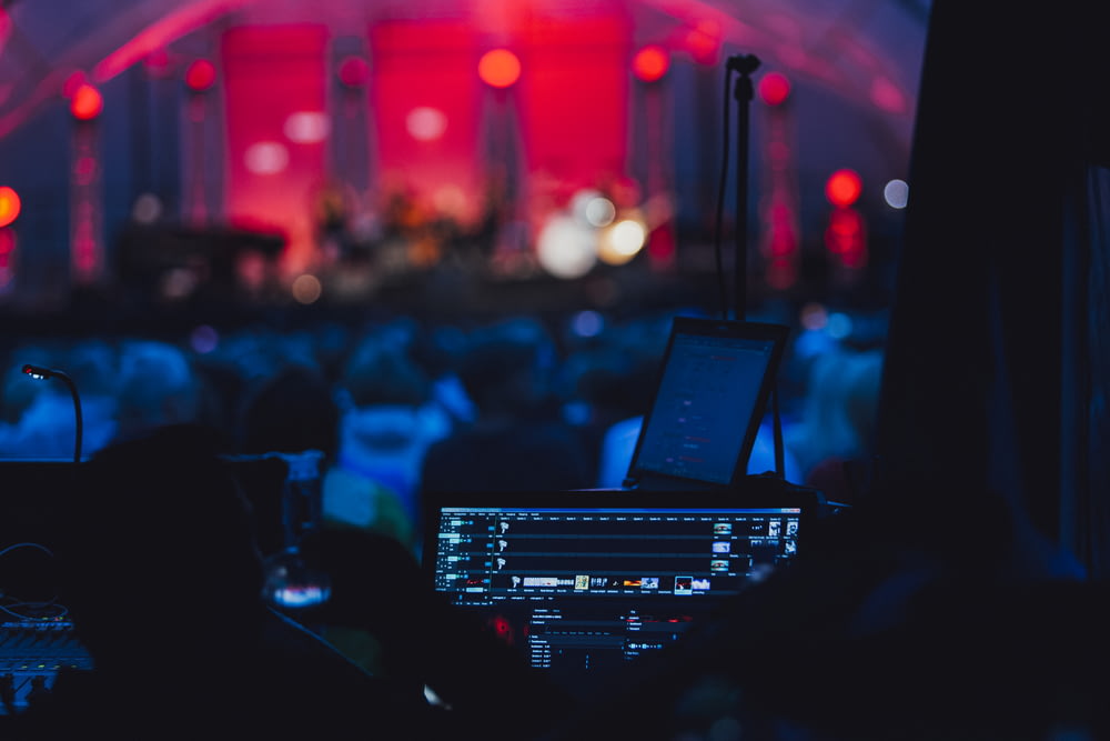 Un escenario con una computadora portátil y un micrófono frente a una multitud