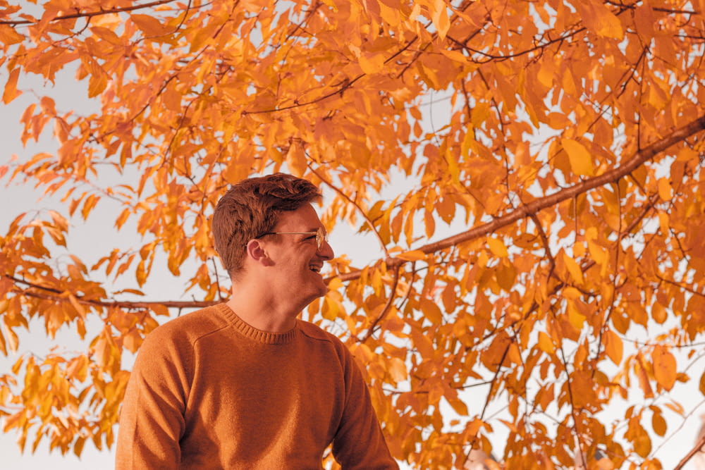 man standing in front of brown leaf tree