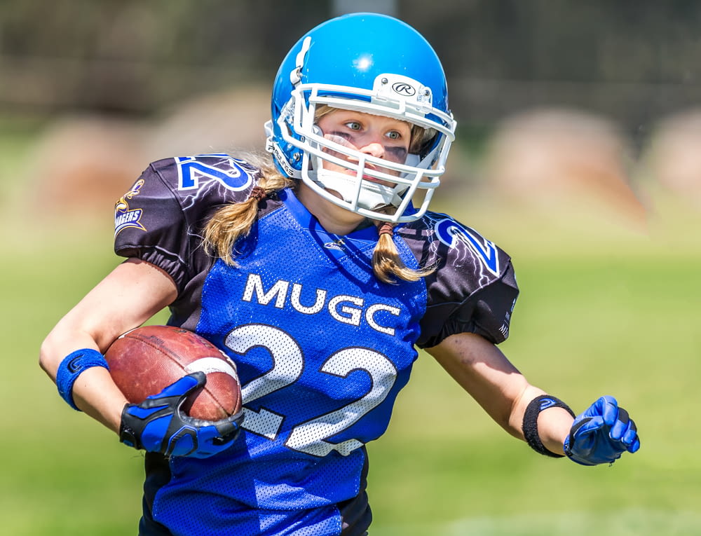 woman in blue helmet playing football