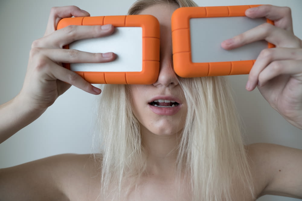 woman holding two white-and-orange plastic cases