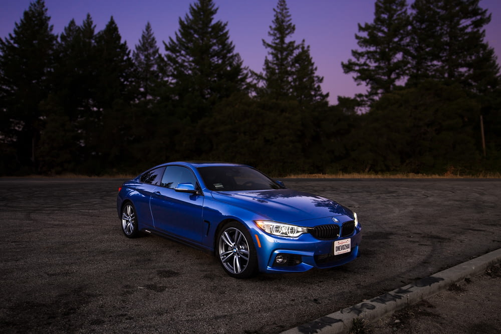 blue BMW coupe on brown asphalt road