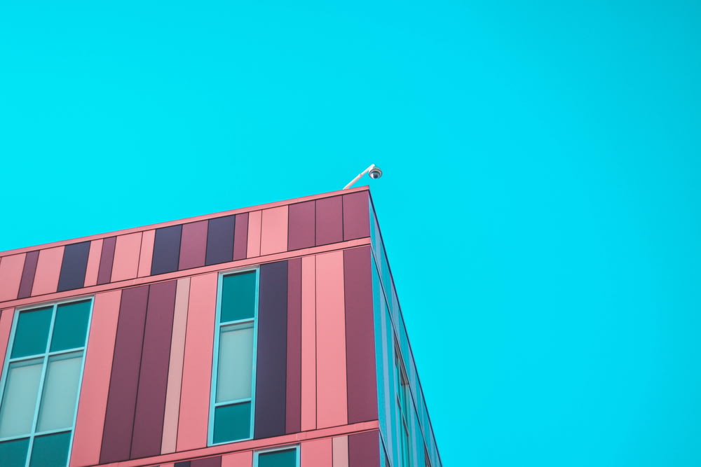 minimalist photography of high-rise building under blue sky