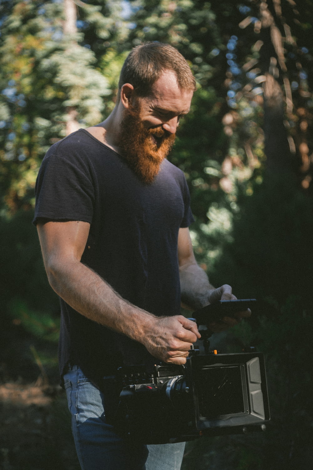 man holding black video recorder in the woods