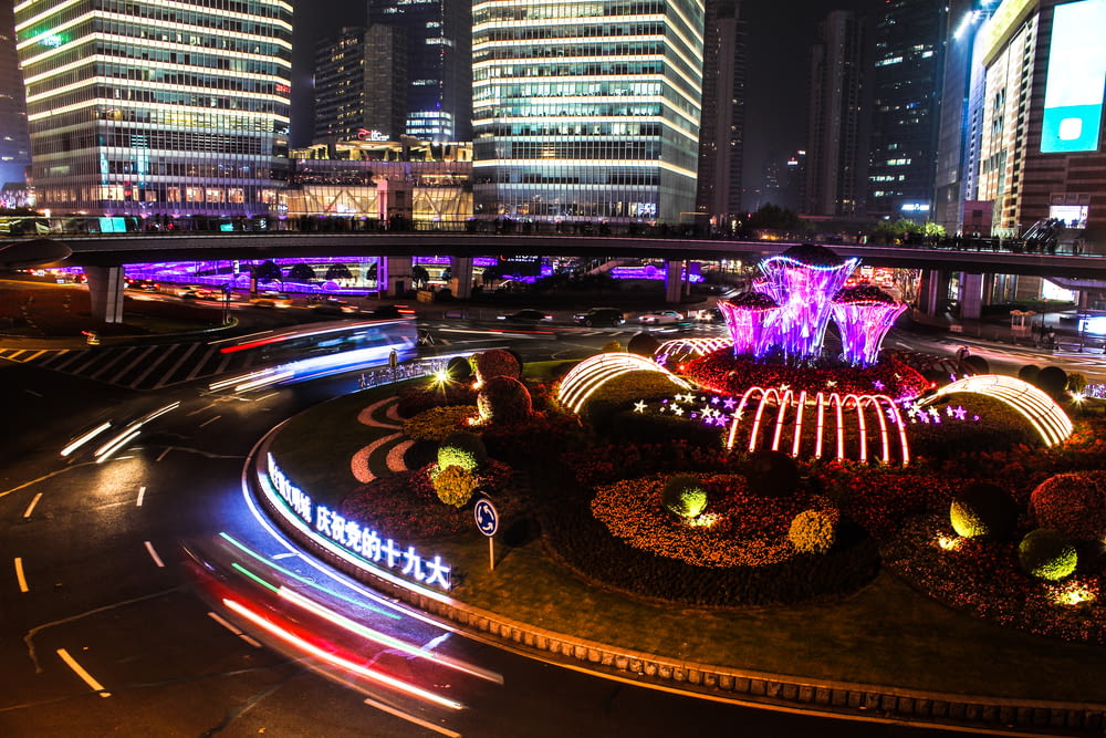 time-lapse photography of lighted fountain near buildings at night time
