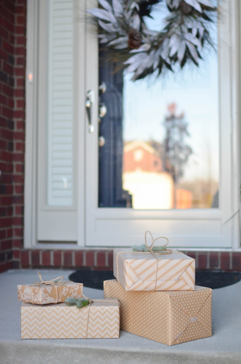 Quattro scatole regalo marroni vicino alla porta bianca