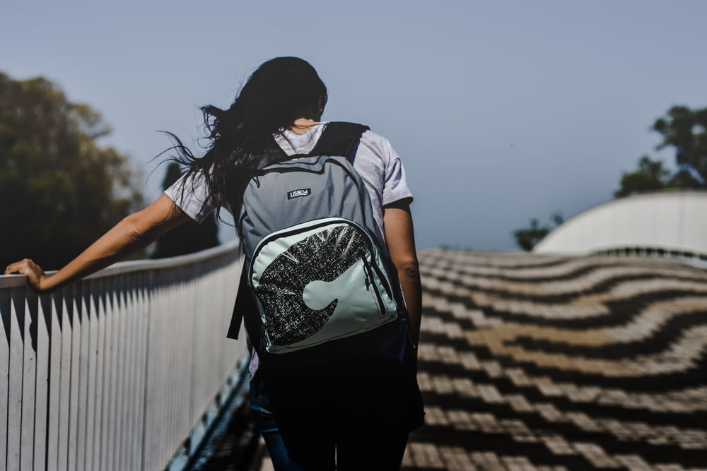 woman walking at bridge wearing backpack