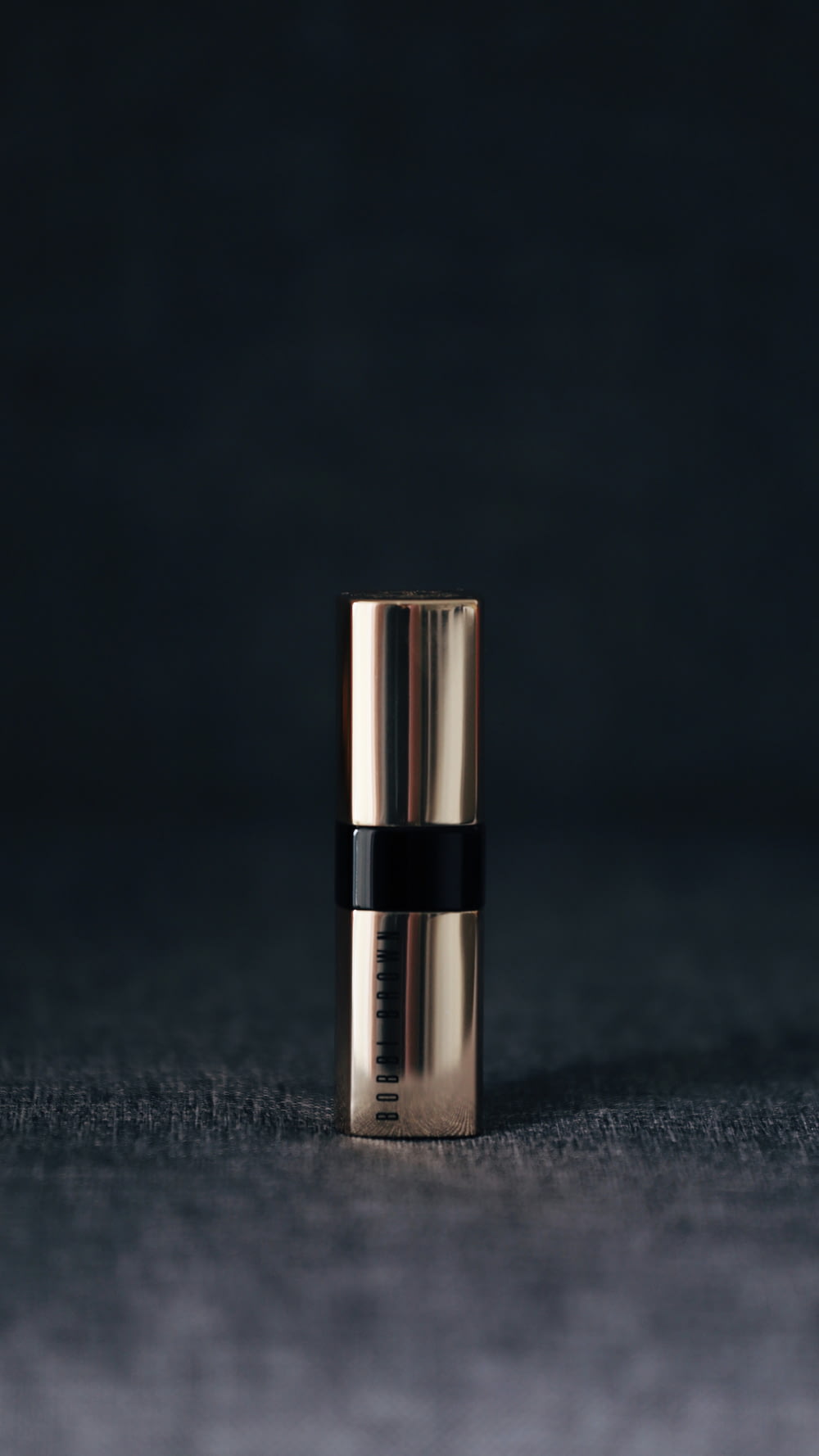 grey lipstick container in selective focus photography