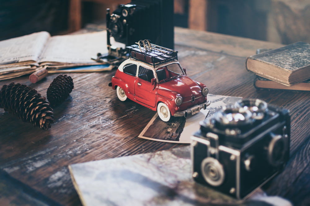 松ぼっくりの横の赤い車両ダ�イキャストモデルのフォーカス写真