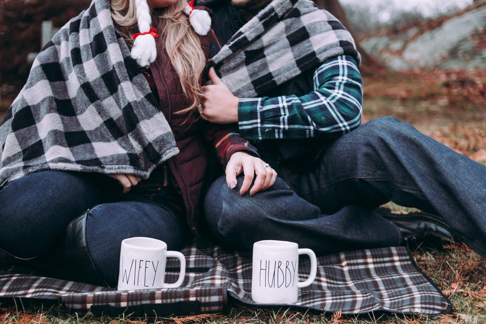 two person cuddling on gray plaid mat