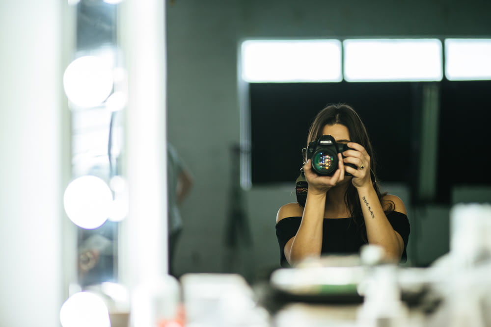 woman taking photo of herself in the mirror