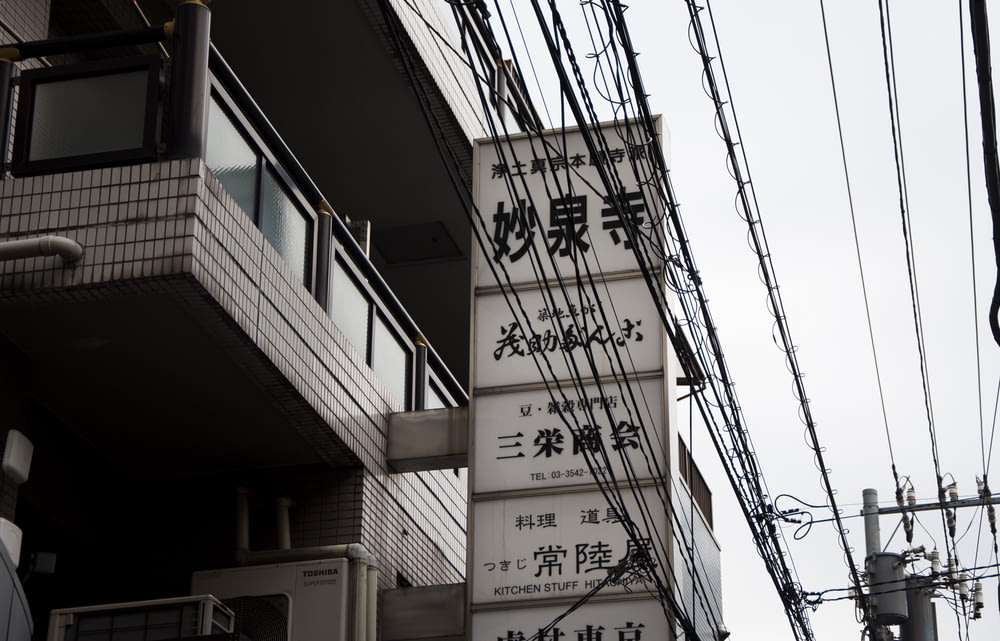 white and black kanji text signage beside of building