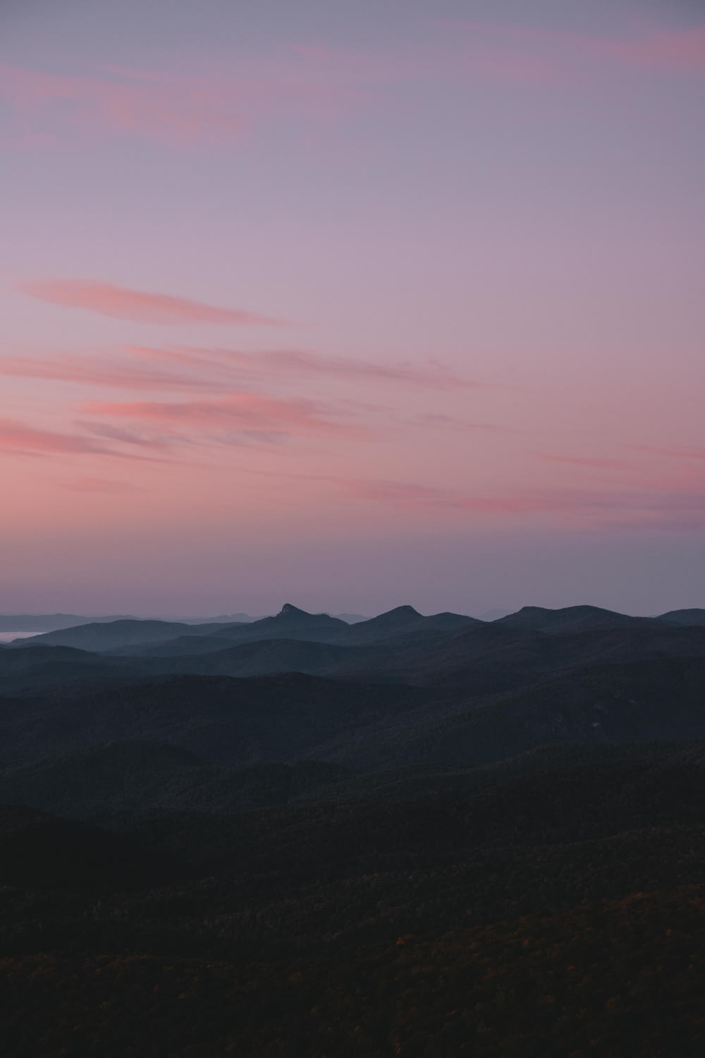 silhouette of mountains under pink sky