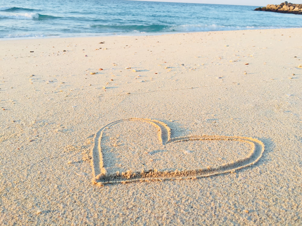 Corazón dibujado en la arena durante el día