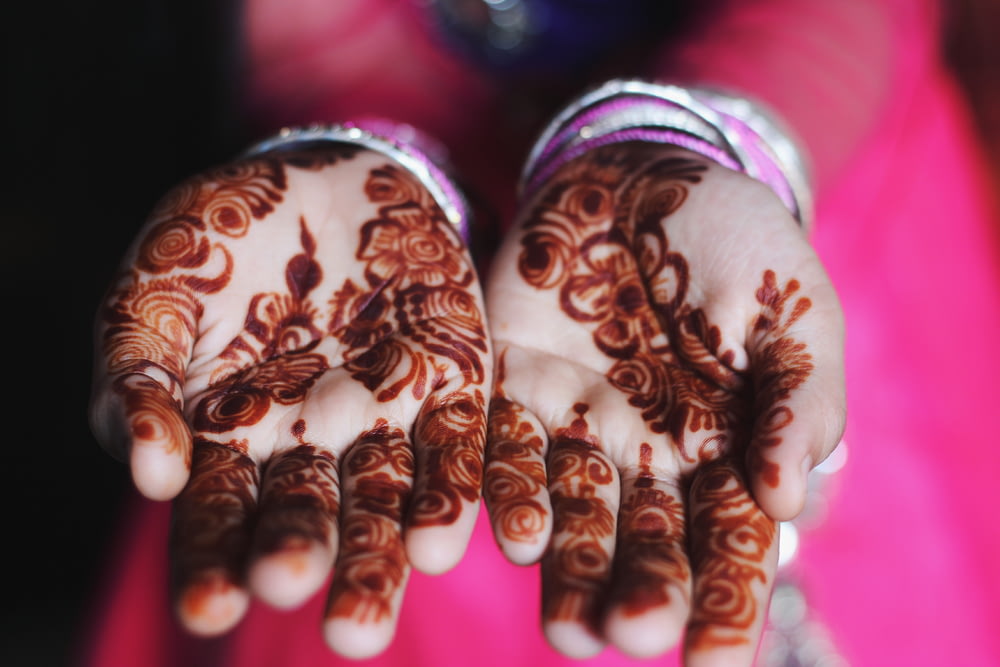 Hand mit schwarzen floralen Henna-Tattoos