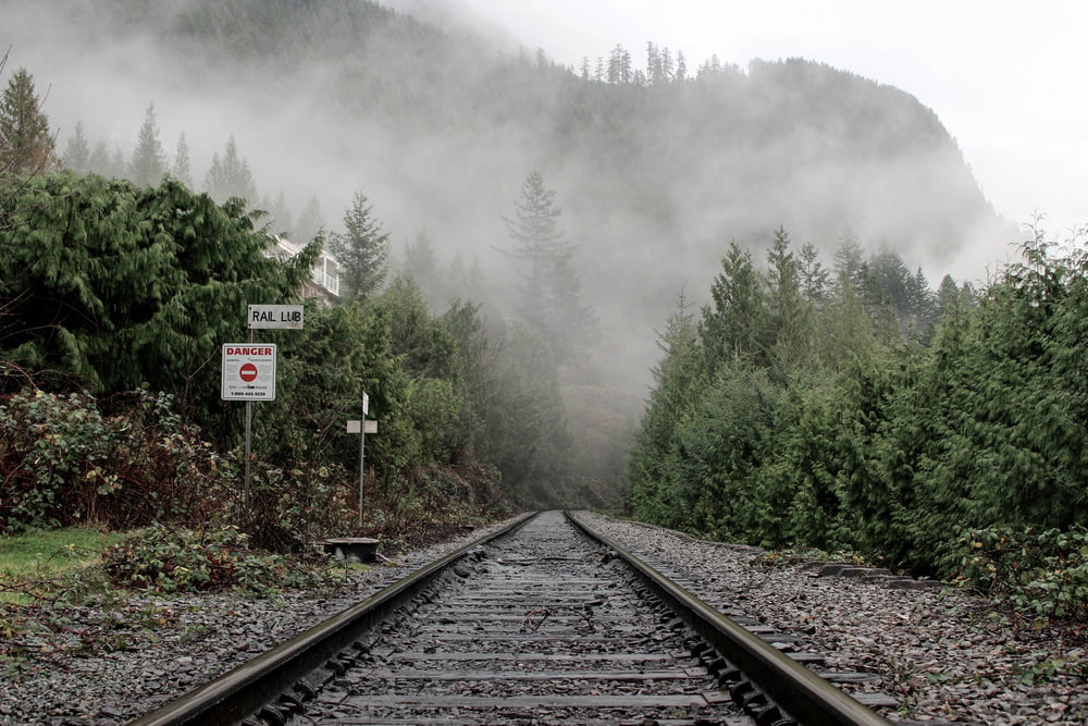 railroad leading to mountain covered with fogs