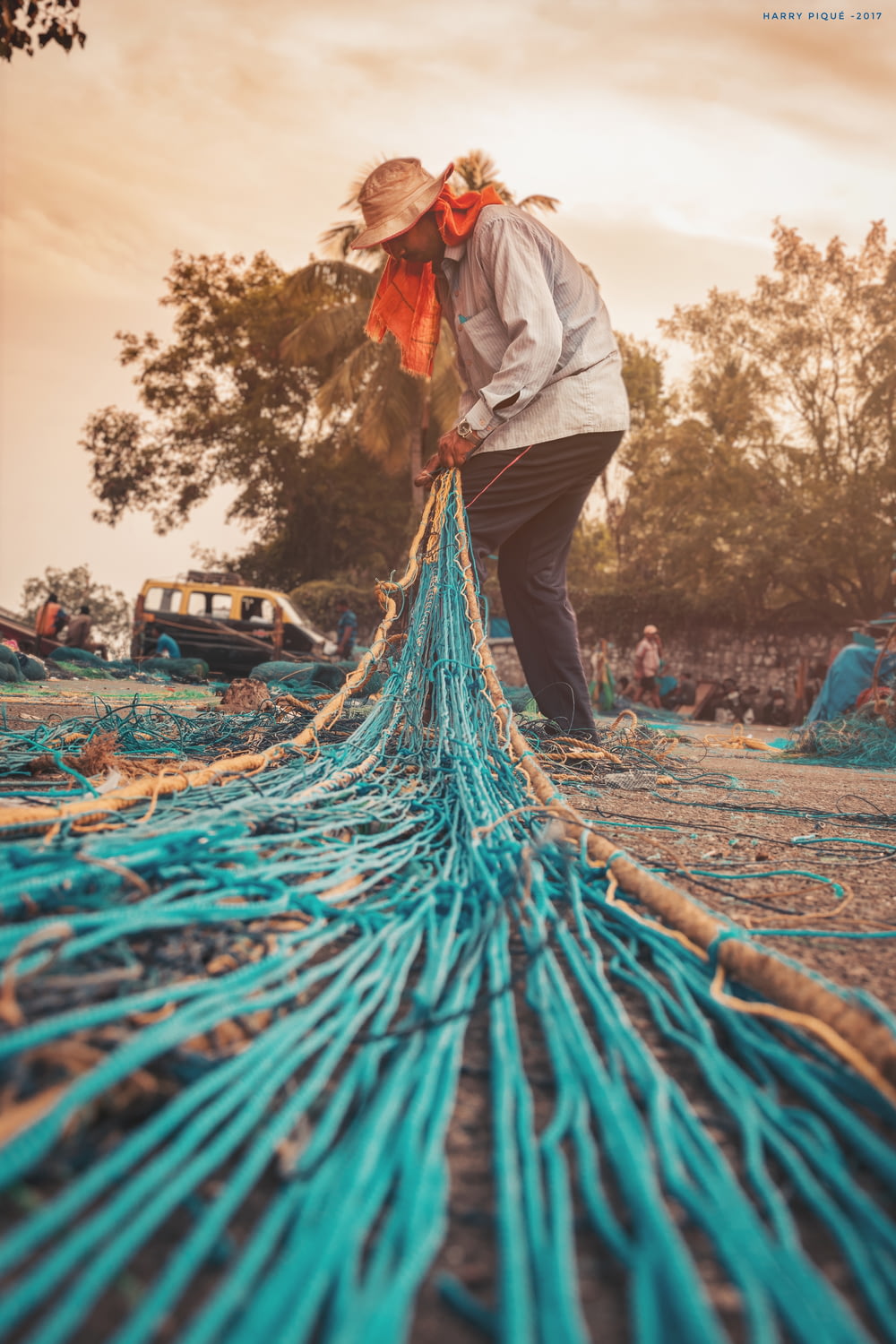 man knitting blue fishing net
