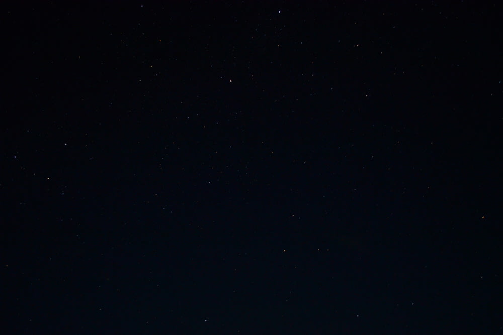 um céu noturno com estrelas e algumas nuvens