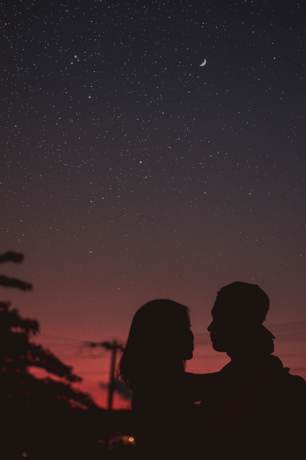 silhouette di donna che abbraccia mna sotto il cielo notturno stellato