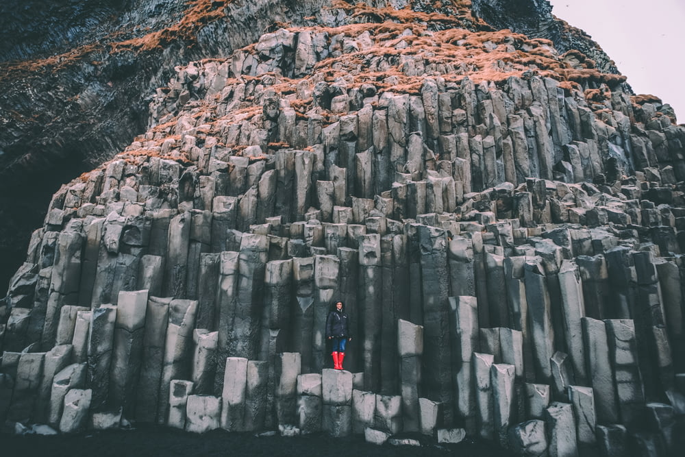 woman standing on grey rock mountain