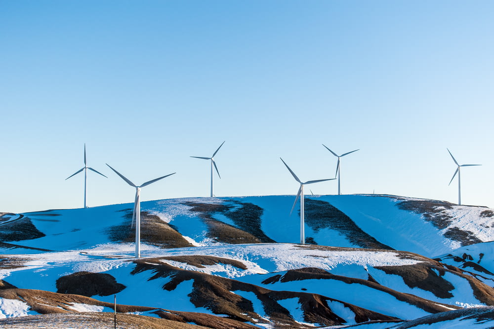 windmills surrounded by snow-covered field during daytime