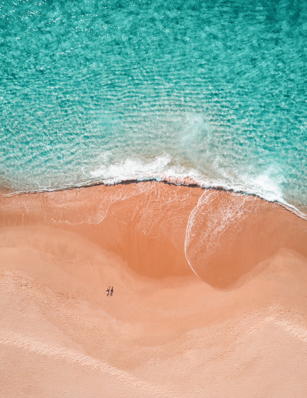 해변에서 일광욕을 하는 두 사람의 항공 사진