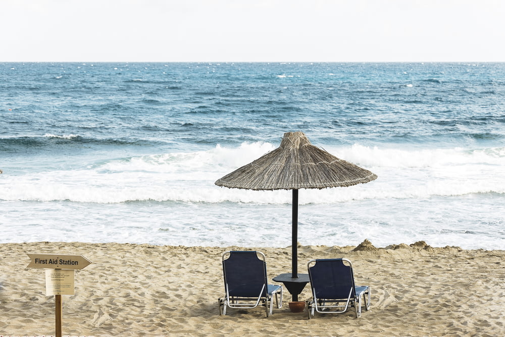 two black beach chair on the seashore