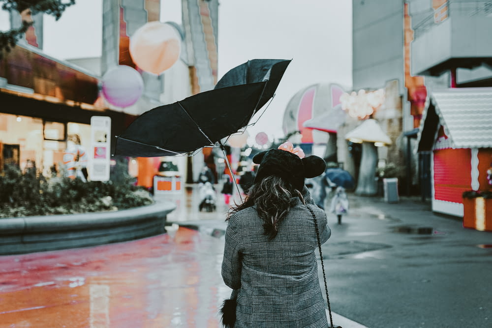pessoa segurando guarda-chuva preto durante o dia