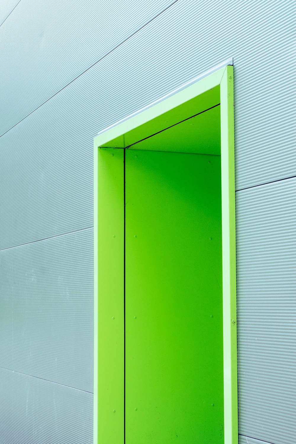 灰色の壁の緑のドア