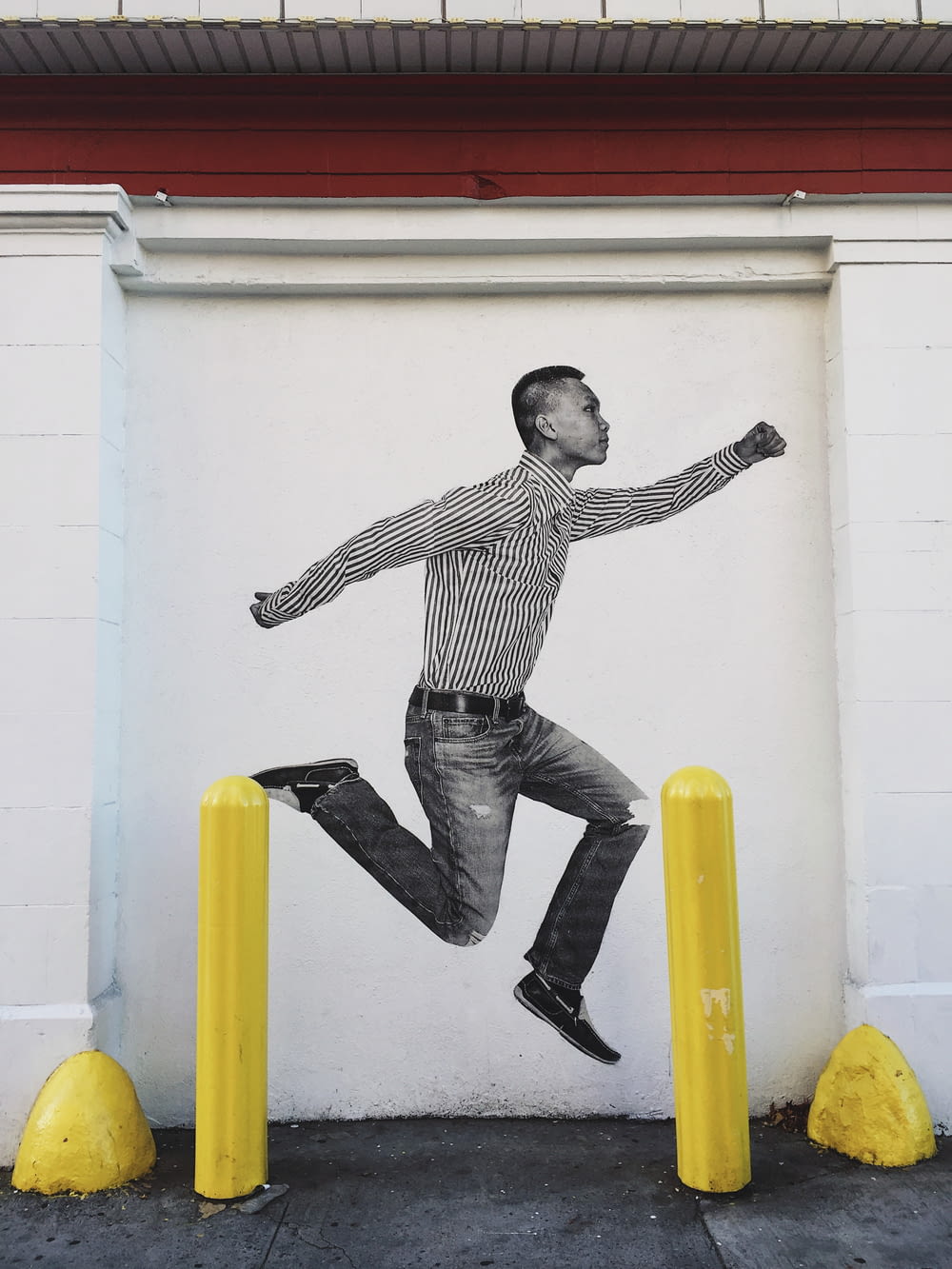 a painting of a man jumping over yellow poles